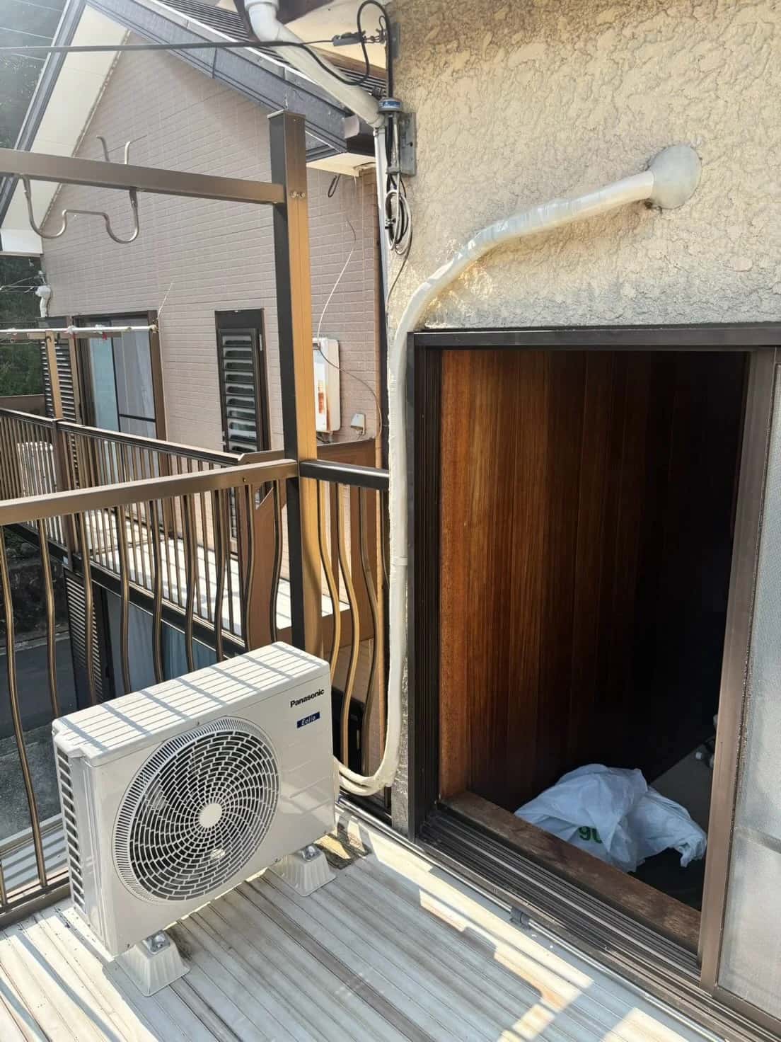 1台目の取替後の、ベランダに置いた室外機と配管