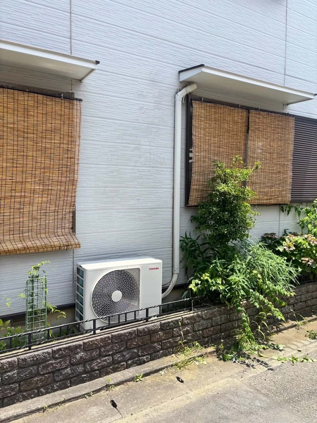 取替後のエアコン室外機と、外壁に沿って立ち上げた配管カバー