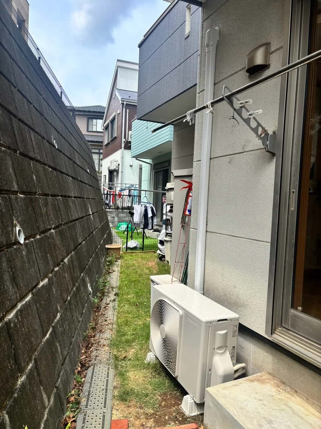 配管を白い化粧カバーで仕上げた、取替後のエアコン室外機