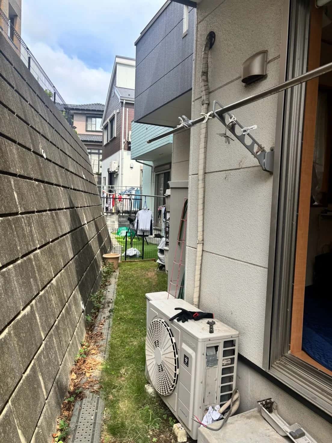 取替前の室外機と、テープを巻いた配管
