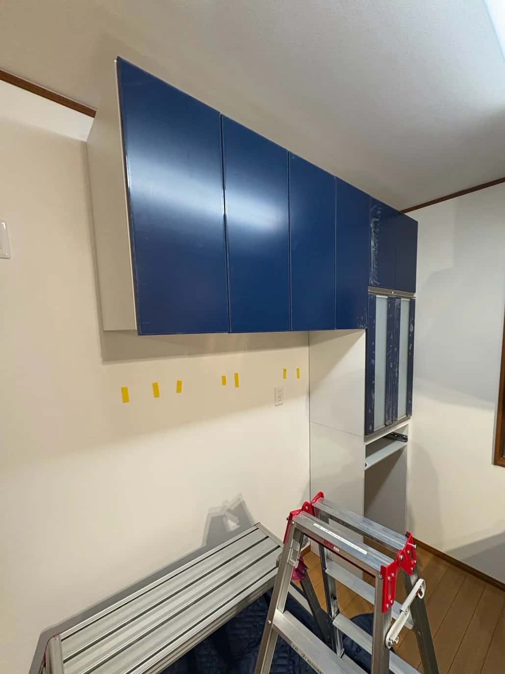 壁に吊り戸棚を取り付けたところ。下の収納は、これから据える